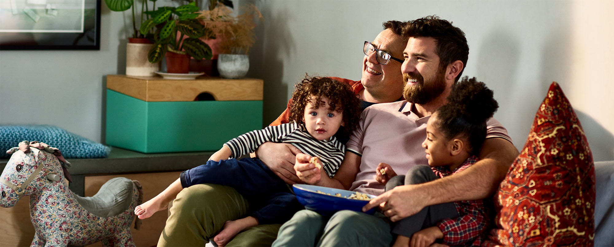 Family with young children sits on couch